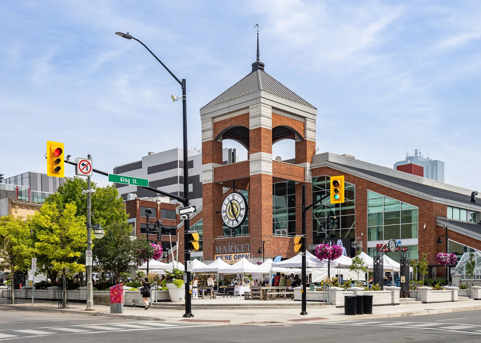 Covent Garden Market in downtown London, Ontario, its brick clock tower and outdoor stalls seen from King Street in daylight.