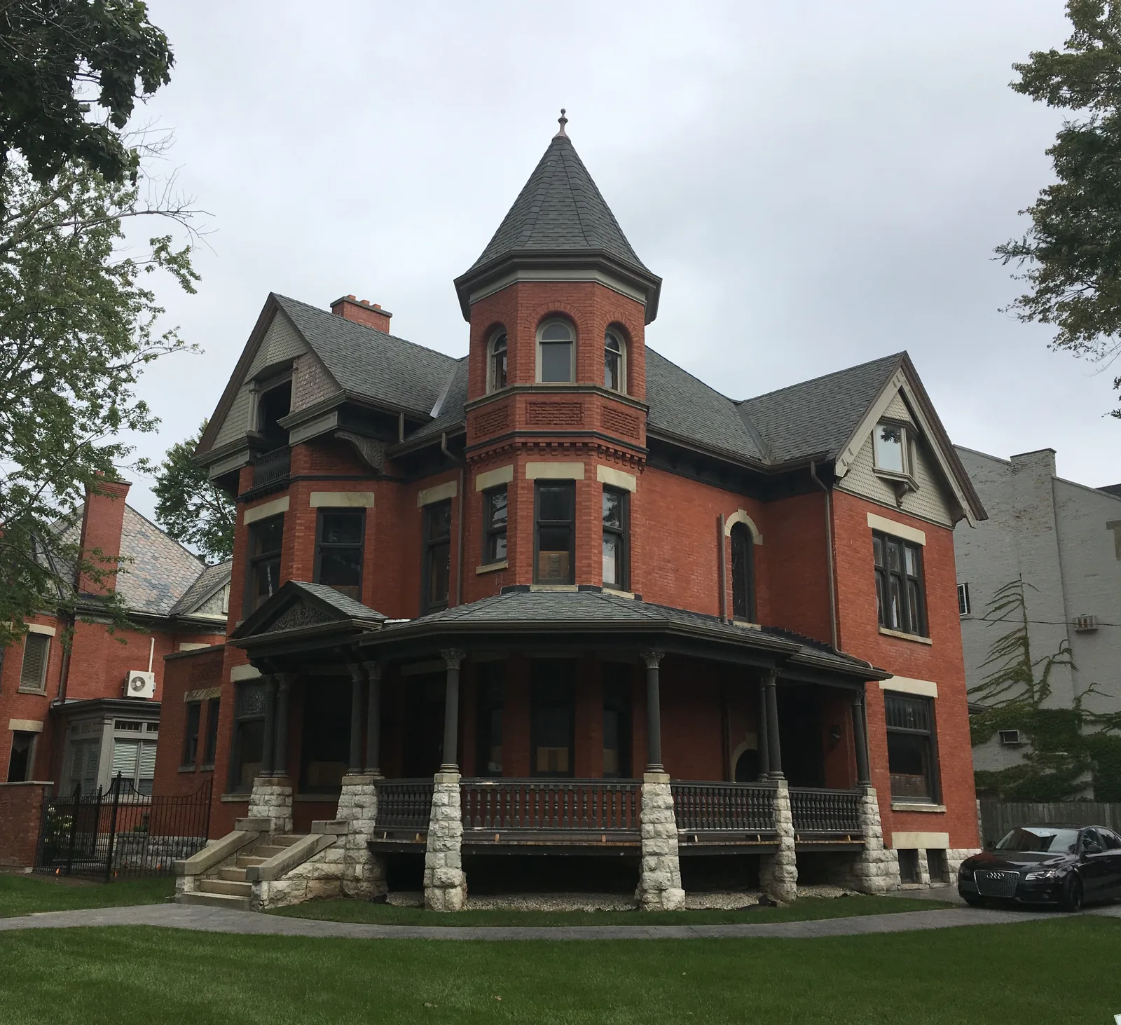 A red-brick Victorian house with a corner turret and wraparound porch at 496 Waterloo Street, London, Ontario.
